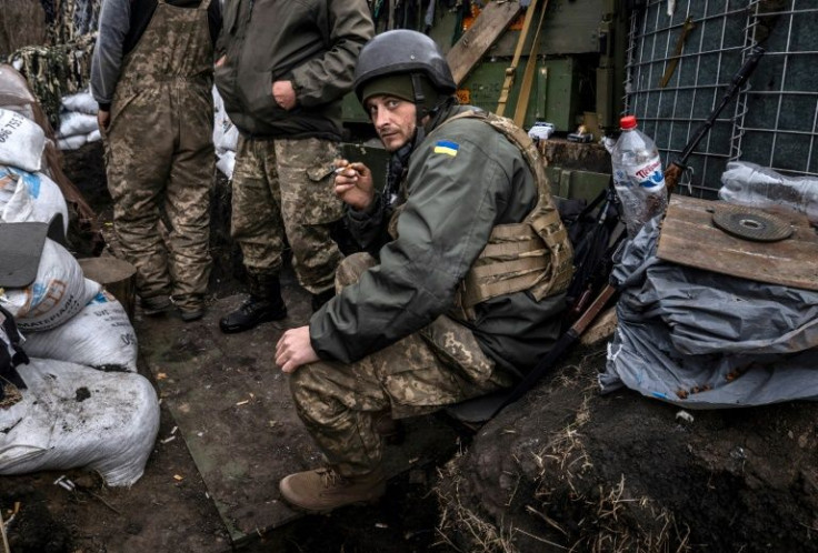 A Ukrainian serviceman smokes a cigarette in a trench at the front line east of Kharkiv on March 31, 2022