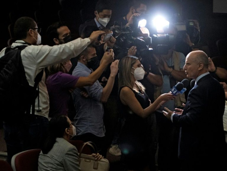 Costa Rican presidential candidate Jose Maria Figueres (R) of the National Liberation Party is surrounded by the press after a debate in San Jose, on March 29, 2022