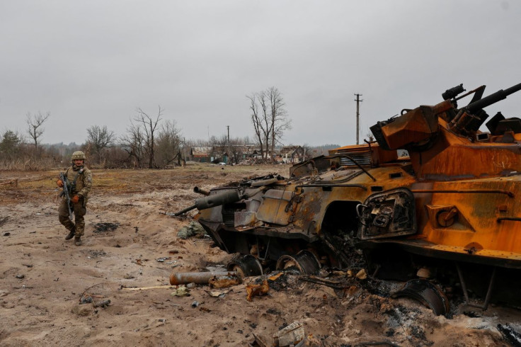 A Ukrainian service member inspects destroyed Russian BTR-82 armoured personal carrier (APC) in a village near a frontline, as Russia's attack on Ukraine continues, in Kyiv Region, Ukraine March 31, 2022.  