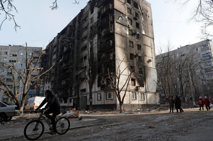 A local resident rides a bicycle past an apartment building damaged during Ukraine-Russia conflict in the besieged southern port city of Mariupol, Ukraine March 31, 2022.