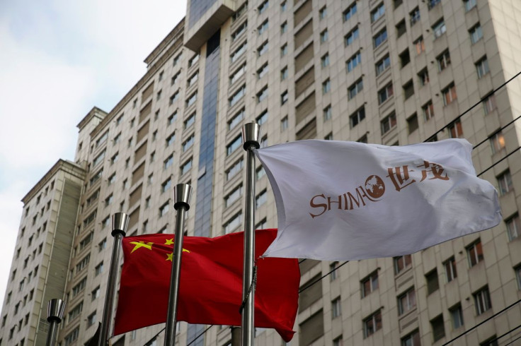 The flag of property developer Shimao Group flutters next to a Chinese flag in Shanghai, China January 13, 2022. 