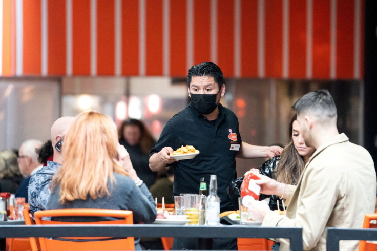 A waiter serves food at a restaurant near Times Square in New York City, U.S., December 16, 2021. 