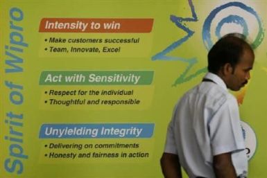 An employee walks pass a billboard in the Wipro campus in Bangalore 