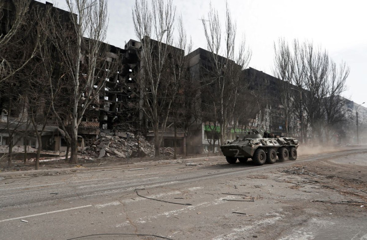 An armoured vehicle of pro-Russian troops drives along a street past a residential building destroyed during Ukraine-Russia conflict in the besieged southern port city of Mariupol, Ukraine March 31, 2022.