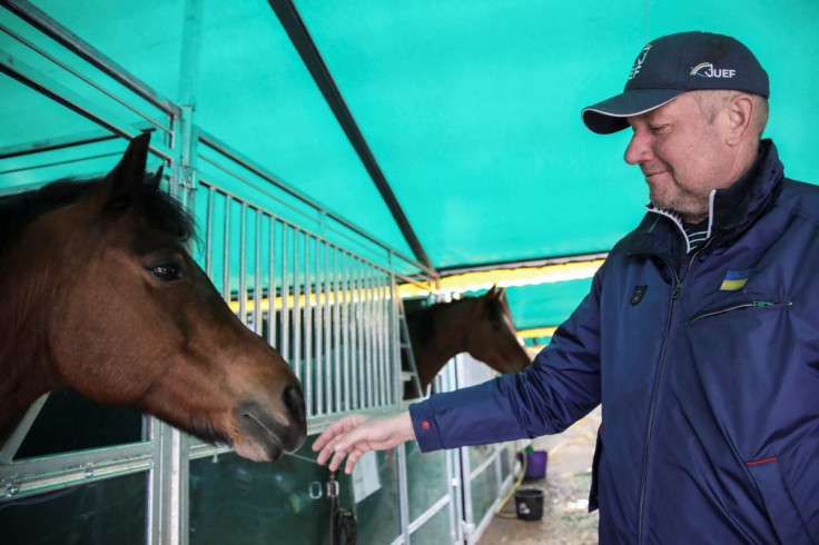 Mykhailo Parkhomchuk, founder of the Ukrainian Equestrian Federation Charity Foundation, pets a horse in a makeshift stable, as Russia's attack on Ukraine continues, in Lviv region, Ukraine, April 1, 2022. 
