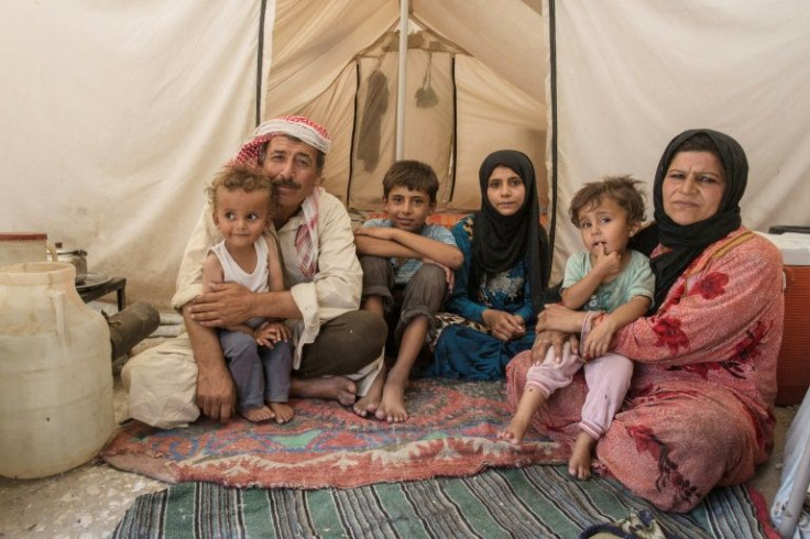 A Syrian family from Raqqa inside a tent in a camp for people displaced by the war against the Islamic State (IS) group, in Ain Issa, after the US battle to liberate Raqqa, which saw massive damage to civilians