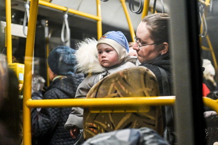 A woman holds a child inside an evacuee bus as people flee from Mariupol and Melitopol amid Russiaâs attack on Ukraine, at a collecting point in Zaporizhzhia, Ukraine April 1, 2022. Picture taken April 1, 2022. 