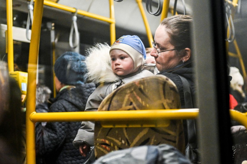 A woman holds a child inside an evacuee bus as people flee from Mariupol and Melitopol amid Russiaâs attack on Ukraine, at a collecting point in Zaporizhzhia, Ukraine April 1, 2022. Picture taken April 1, 2022.