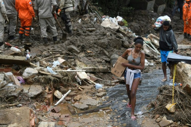 In this photo taken on February 19, 2022, people carry belongings after a giant landslide in Petropolis, Brazil