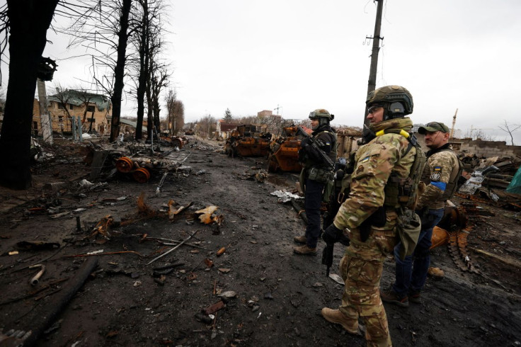 Soldiers walk to see destroyed Russian military vehicles, amid Russia's invasion on Ukraine in Bucha, in Kyiv region, Ukraine April 2, 2022. 