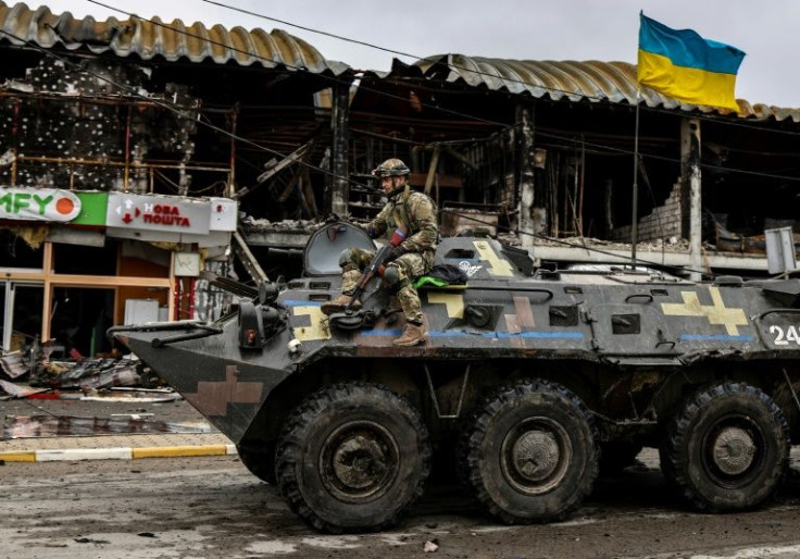 An Ukranian soldier patrols a street in Bucha