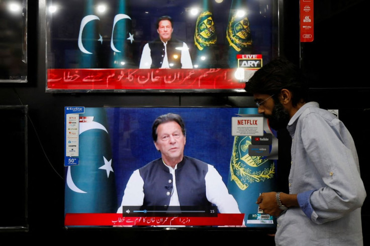 A shopkeeper tunes a television screen to watch the speech of Pakistani Prime Minister Imran Khan, at his shop in Islamabad, Pakistan, March 31, 2022. 