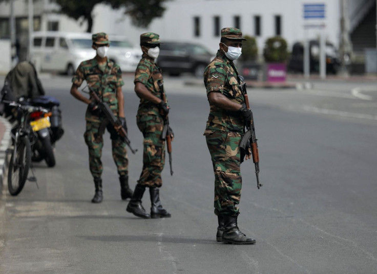 Sri Lankan army soldiers stand guard at a checkpoint after the government imposed a curfew following a clash between police and protestors near Sri Lankan President Gotabaya Rajapaksa's residence during a protest last Thusrday, amid the country's economic