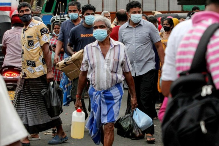 People crowd a marketplace to stock up on essential items in Colombo
