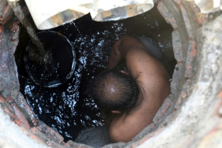 Nearly naked and covered with a black, foul-smelling muck, Shafiq Masih struggles out of a sewer he has just cleaned by hand in an upmarket district of Lahore, Pakistan's second biggest city
