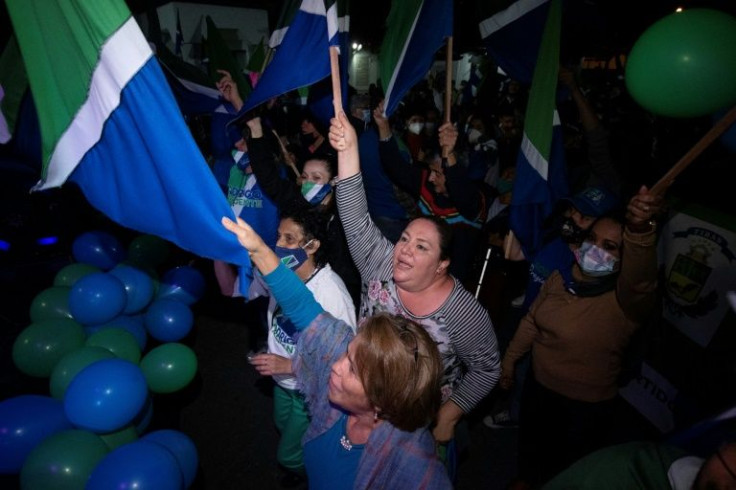 Rodrigo Chaves supporters wave flags at a campaign rally in San Jose on March 25, 2022