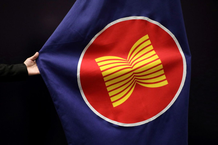 A worker adjusts an ASEAN flag at a meeting hall in Kuala Lumpur, Malaysia, October 28, 2021. 