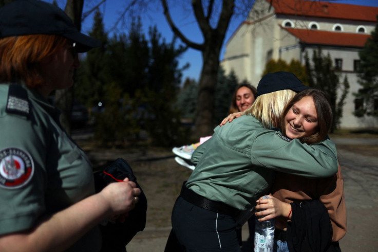 Law enforcement workers who helped Ukrainian refugee Alexandra Zhuravel, 38, and her daughters Viktoria Bravorichenko, 12, and Alevtina Bravorichenko-Crane, 8, and dog Luna, cross the Ukraine-Poland border to visit them at the Benedictine Sisters Monaster