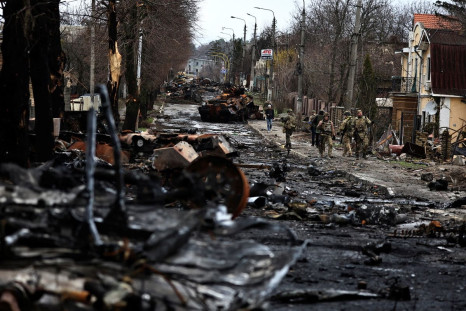 Soldiers walk past a destroyed Russian tank and armoured vehicles, amid Russia's invasion on Ukraine in Bucha, in Kyiv region, Ukraine April 2, 2022. 