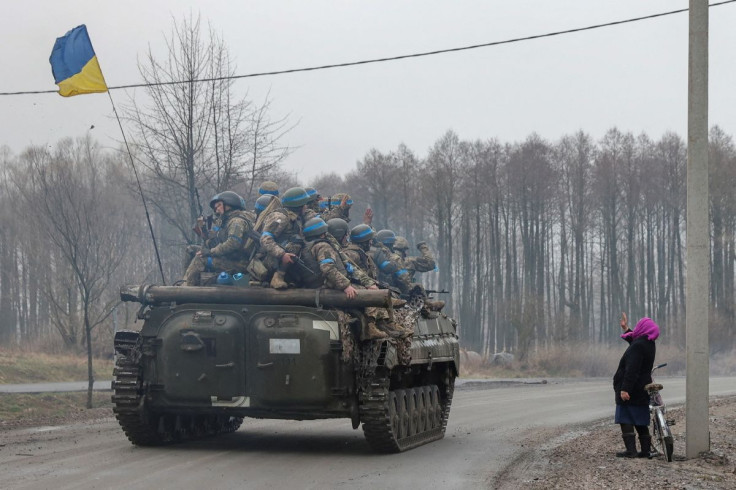 A local woman salutes Ukrainian service members, as Russia's attack on Ukraine continues, in Chernihiv region, Ukraine April 2, 2022. Picture taken April 2, 2022. 