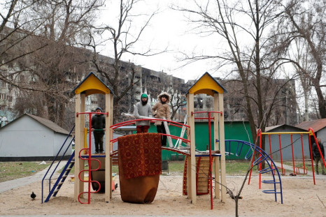 Children play at the playground near an apartment building damaged during Ukraine-Russia conflict in the southern port city of Mariupol, Ukraine April 4, 2022. 
