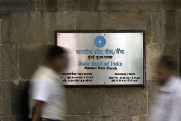 People walk in front of a signboard displayed at the head office of State Bank of India in Mumbai November 9, 2009. 