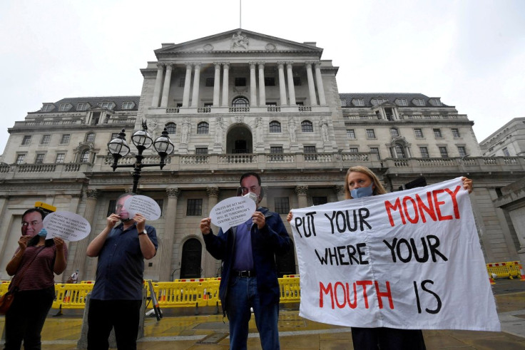 Environmental activists wear face masks depicting the governor of the Bank of England, Andrew Bailey, during a protest to encourage a green economy, outside of the Bank of England in the City of London, Britain, August 6, 2020.
