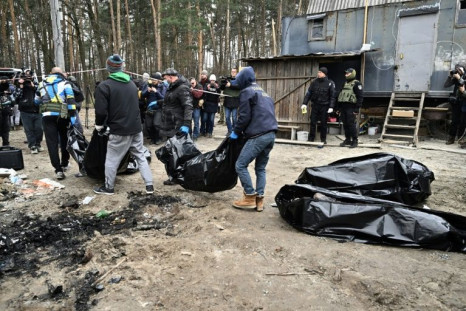 City workers carry bags with six partially burnt bodies in the town of Bucha, where Ukrainian officials accuse Russian forces of carrying out war crimes against civilians