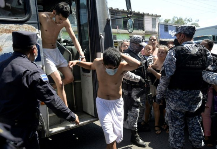 Men captured for alleged gang links are escorted by the National Civil Police during the state of emergency declared by the government in San Salvador on March 31, 2022