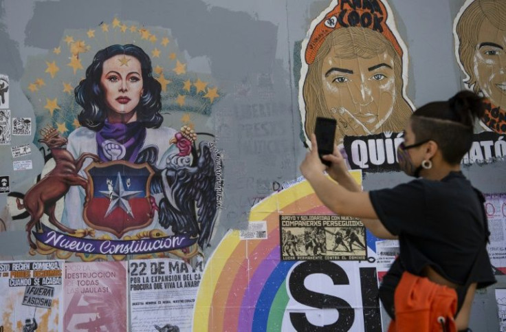 A person takes pictures of a graffiti in support of the October 25 referendum to change Chile's military dictatorship-era constitution, in Santiago in October 2020