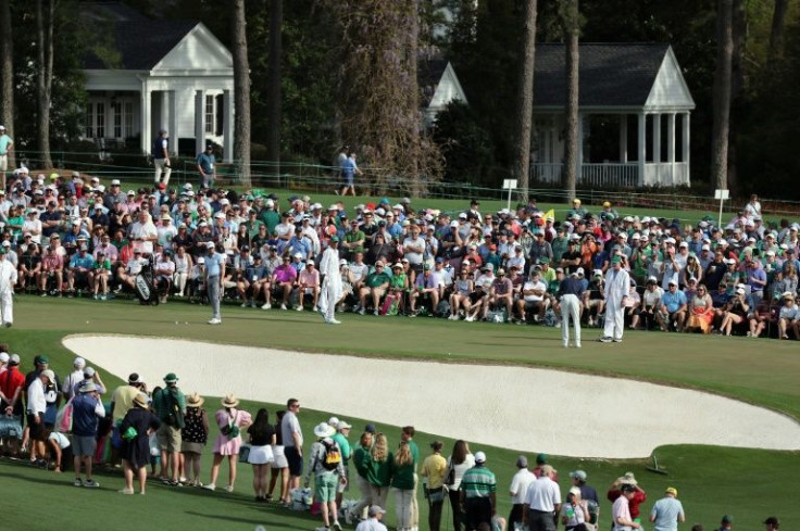 Eyes on the Tiger: Tiger Woods puts in a practice round at Augusta National, watched by fellow pro Justin Thomas and a throng of spectators