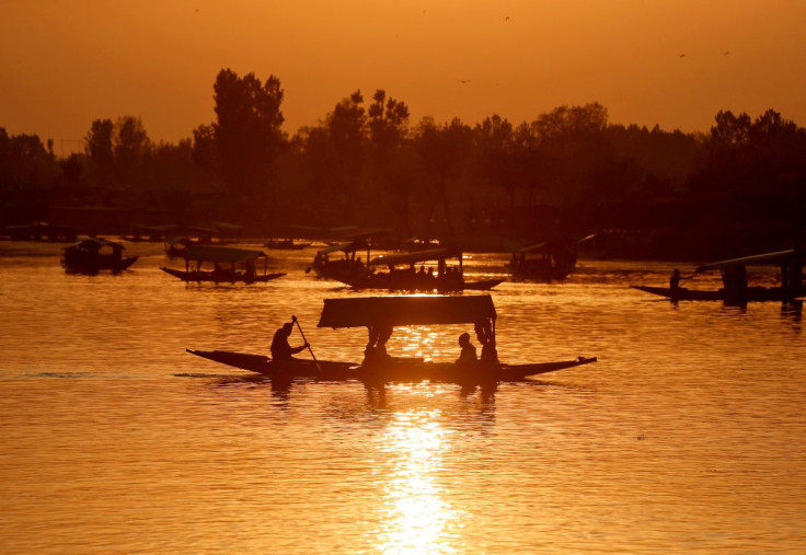 Tourists ride "Shikaras" or boats in the waters of Dal Lake during sunset in Srinagar, April 5, 2022.