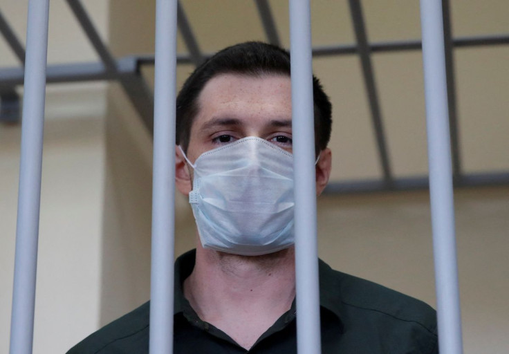 Former U.S. Marine Trevor Reed, who was detained in 2019 and accused of assaulting police officers, stands inside a defendants' cage during a court hearing in Moscow, Russia July 30, 2020.