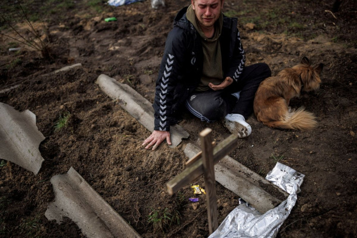 Serhii Lahovskyi, 26, mourns next to the grave of his friend Ihor Lytvynenko, who according to residents was killed by Russian soldiers, after they found him beside a building's basement, amid Russia's invasion of Ukraine, in Bucha, in Kyiv region, Ukrain