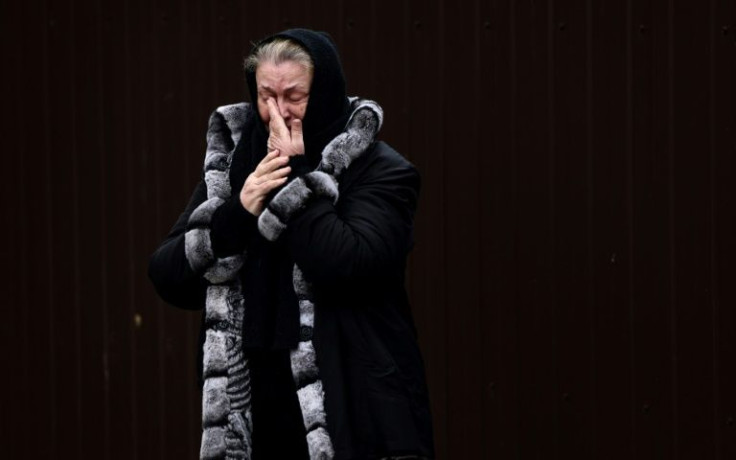 Bucha resident Tetiana Ustymenko weeps over the grave of her son, buried in the garden of her house, in Bucha, northwest of Kyiv, on April 6, 2022