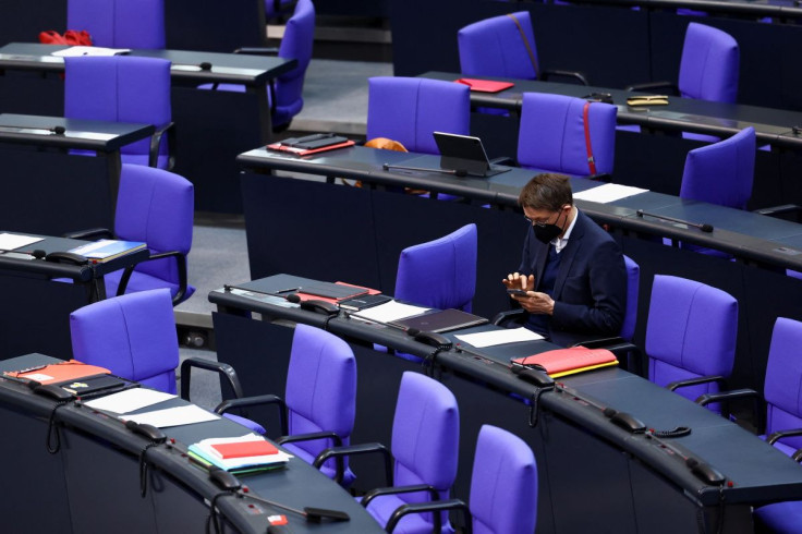 German Health Minister Karl Lauterbach checks his phone during a session of Germany's lower house of parliament, as the Bundestag votes on several proposals introducing or blocking a coronavirus disease (COVID-19) vaccine mandate for the general populatio