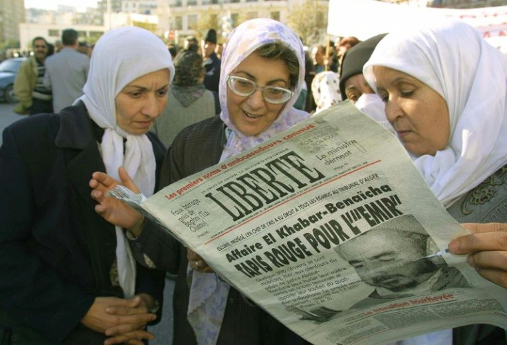 Women in Algiers read the independent Algerian daily "Liberte" on January 11, 2001 -- the paper called itself "a reference for all viewpoints"