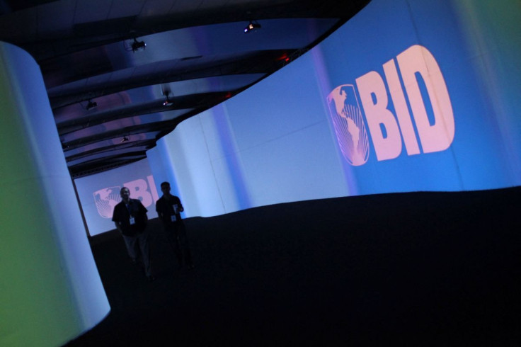 Visitors walk past a screen with the logo of Banco Interamericano de Desarrollo (BID) at the Atlapa Convention Center in Panama City March 13, 2013.