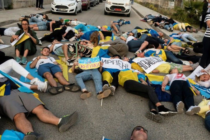 Demonstrators in Nicosia pose as dead bodies in a mock massacre during a demonstration in solidarity with Ukraine outside a meeting of the Cypriot parliament which Ukrainian President Volodymyr Zelensky addressed by video link