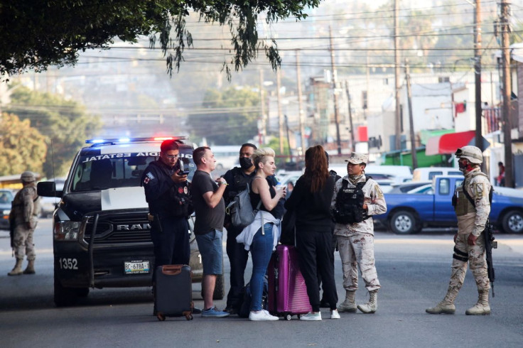 Ukrainians who fled to Mexico amid the Russian invasion of Ukraine are questioned by police officers and soldiers while heading toward a shelter after arriving in Tijuana to enter the U.S., in Tijuana, Mexico, April 6, 2022.