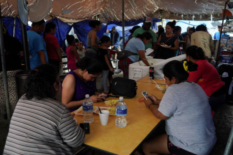 Migrants that were mostly sent back to Mexico wait to receive a meal prepared by other migrants that live at the encampment yards away from the border as they hope to be allowed into the U.S. when Title 42 is lifted, in Reynosa, Mexico, April 1, 2022.   