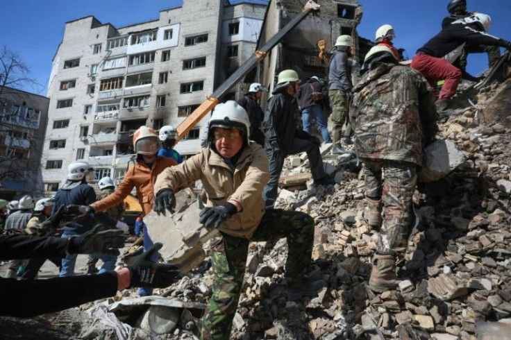 Volunteers help rescuers remove rubble from a damaged building in the Ukrainian town of Borodianka, northwest of Kyiv, where President Volodymyr Zelensky warned of destruction 'much more horrific' than that uncovered in the nearby town of Bucha