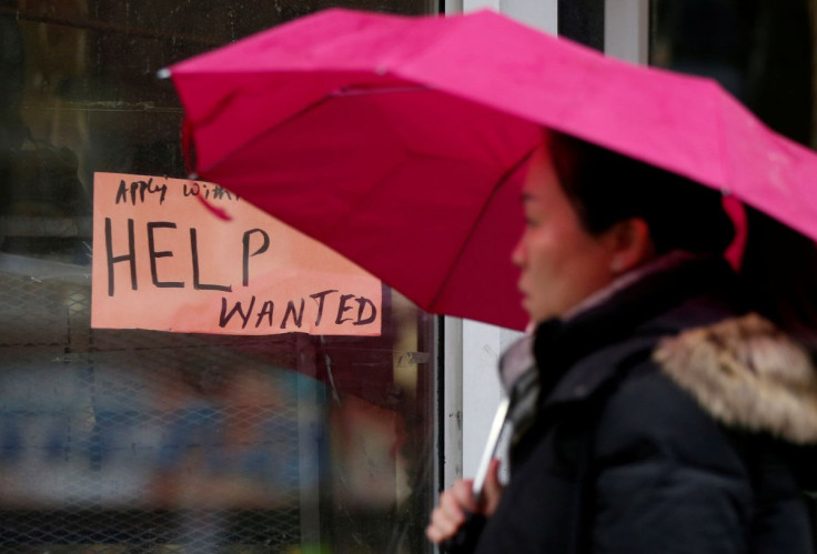 A woman walks past a "Help wanted" sign at a retail store in Ottawa, Ontario, Canada, November 2, 2017.