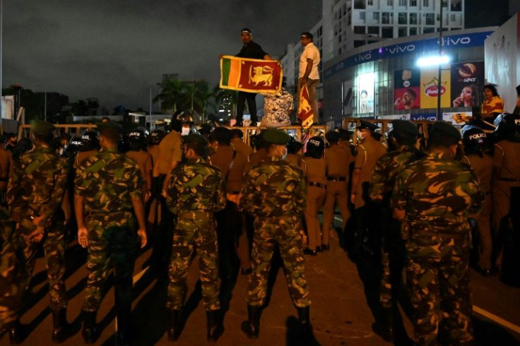 Riot police attempt to block protesters during a rally near the prime minister's house in Colombo