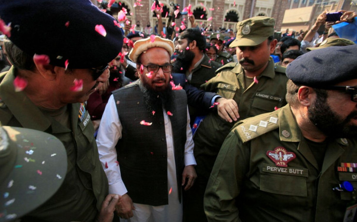 Hafiz Saeed is showered with flower petals as he walks to court before a Pakistani court ordered his release from house arrest in Lahore, Pakistan November 22, 2017.