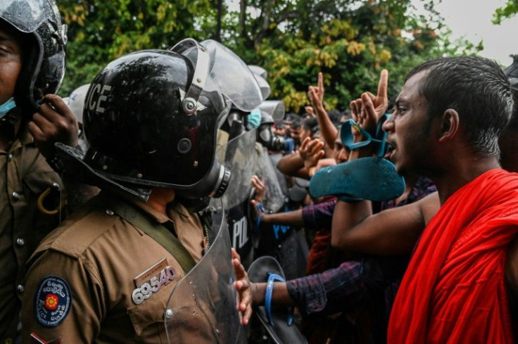 Buddhist monks, including a man in saffron robes and holding his sandals, joined university students taking part in a demonstration in Colombo against Sri Lanka's economic crisis