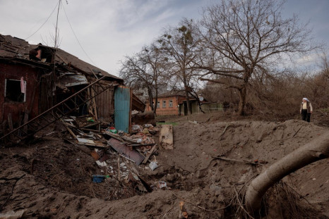 A woman looks at her neighbour's damaged house after a rocket exploded between their homes in a residential area in Kharkiv as Russia's attack on Ukraine continues, Ukraine, April 8, 2022.  
