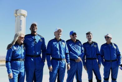 The Blue Origin NS-19 crew stand next to the New Shepard rocket after their successful launch on December 11, 2021