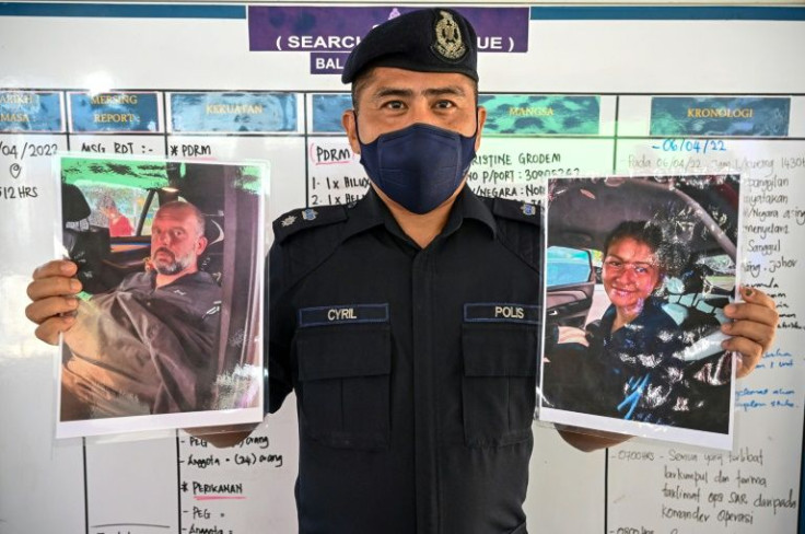 Malaysian police official Cyril Edward shows pictures of two rescued divers: French national Alexia Alexandra Molina (R) and Briton Adrian Peter Chesters