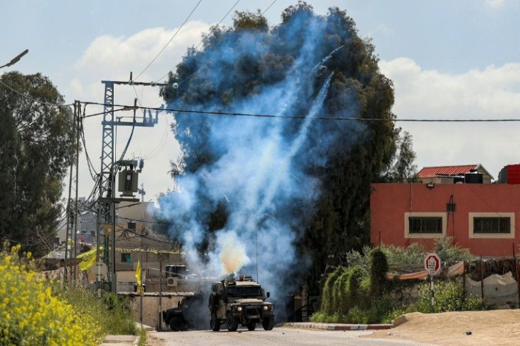 Tear gas canisters are fired from an Israeli military vehicle near the Palestinian refugee camp of Jenin in the occupied West Bank on April 9, 2022